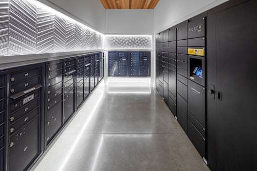 A long hallway with a series of lockers on the side and a light strip on the ceiling.