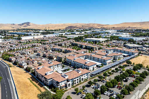 A road runs through a residential area with houses on either side.