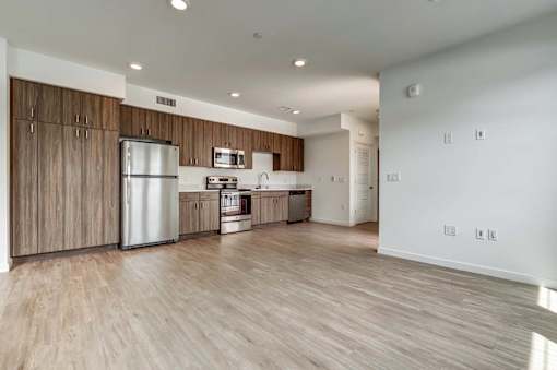 A kitchen with wooden cabinets and a stainless steel refrigerator.