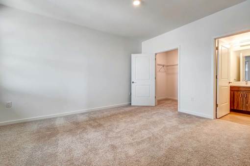 A room with a carpeted floor and a white door.