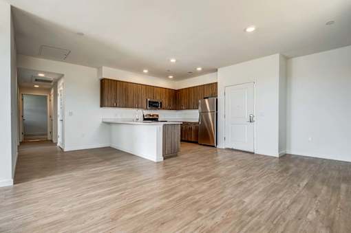 A kitchen with a white countertop and wooden cabinets.