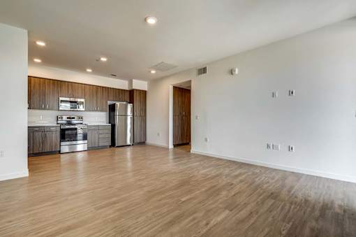A spacious kitchen with wooden floors and modern appliances.