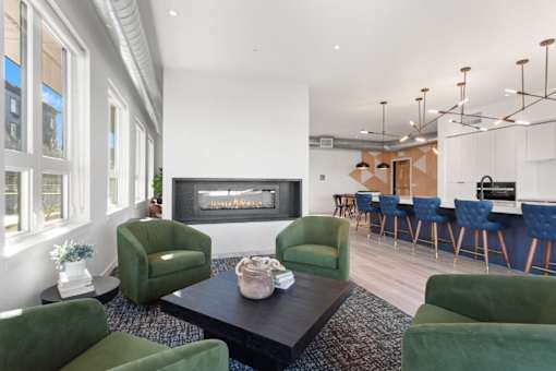 A living room with a fireplace and green chairs.
