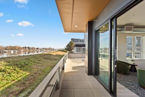 A modern building with a balcony overlooking a river.
