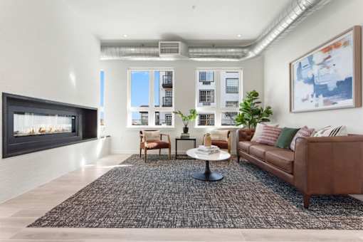 A living room with a brown couch, a coffee table, and a fireplace.