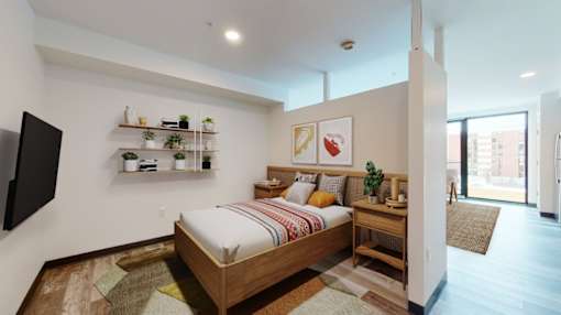 A bedroom with a bed, a TV, and a window.