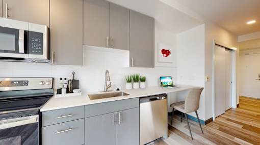A modern kitchen with a microwave, oven, and a sink.