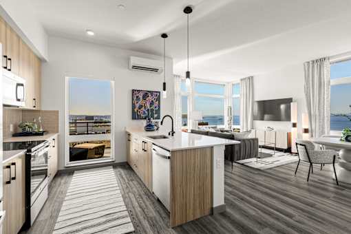 A modern kitchen with a large island and a view of the ocean.
