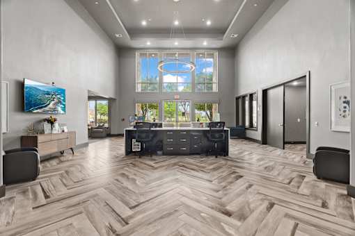A modern office with a large desk and a flat screen TV.