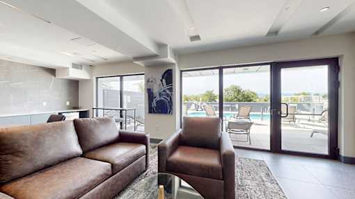 A living room with a brown couch and a chair.
