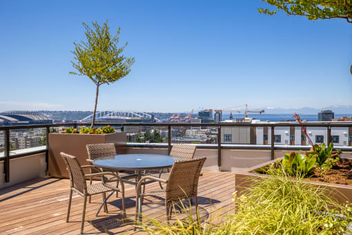 a balcony with a table and chairs and a view of the city