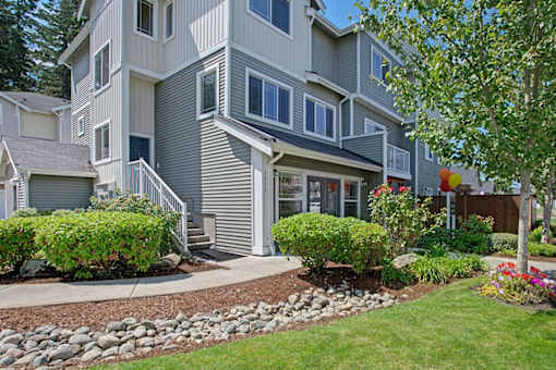 A grey two story house with a front yard.