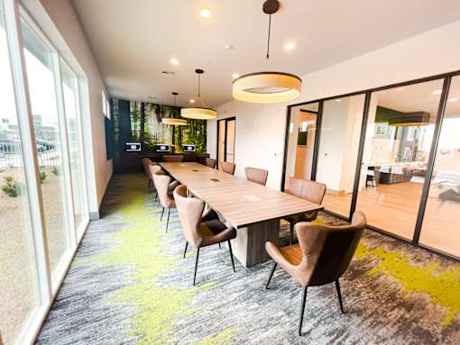A conference room with a long table and chairs.