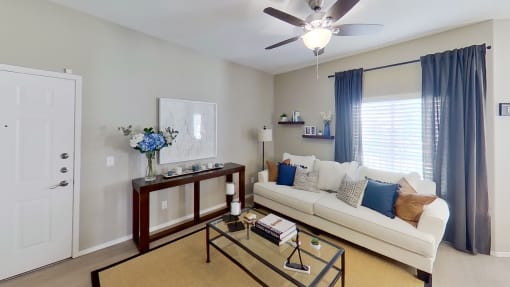 a living room with a white couch and a glass coffee table