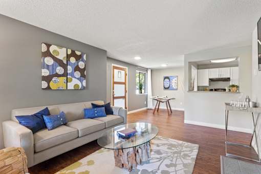 Living room with wood-style flooring and view of dining room area at Cedar Crest Apartments in West Beaverton, Oregon.