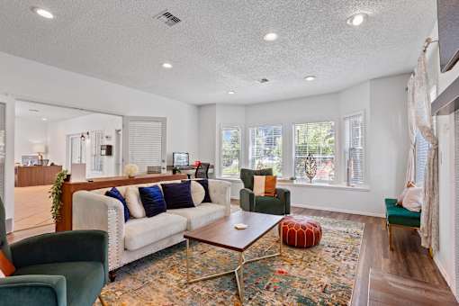 Resident lounge with large windows and kitchen at Cedar Crest Apartments in West Beaverton, Oregon.
