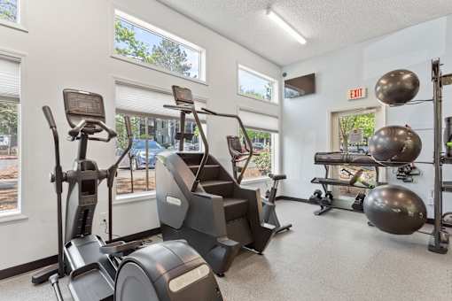Fitness center with machines and weights at Cedar Crest Apartments in West Beaverton, Oregon.
