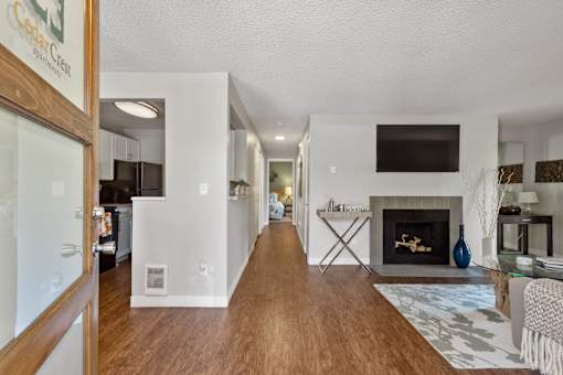 Living room with white walls, fireplace, and wood-style flooring at Cedar Crest Apartments in West Beaverton, Oregon.
