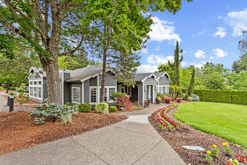 Exterior building with lush landscaping and flowers at Cedar Crest Apartments in West Beaverton, Oregon.