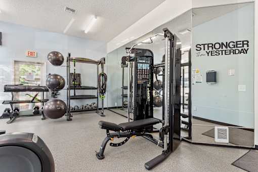 Fitness center with machines and weights at Cedar Crest Apartments in West Beaverton, Oregon.