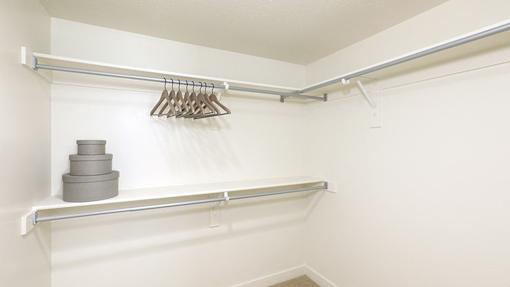 A white closet with a shelf and a hanger.