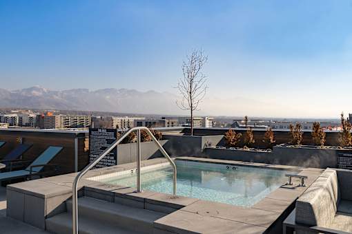 A hot tub on a rooftop with a view of the mountains.