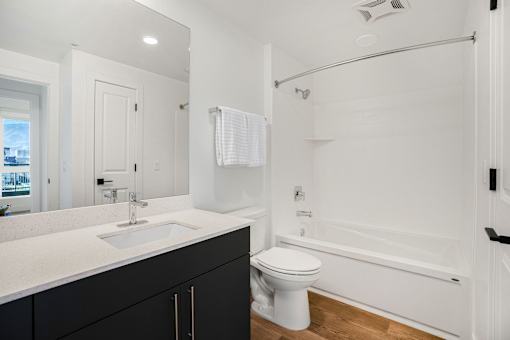 A white toilet sits next to a bathtub in a bathroom.