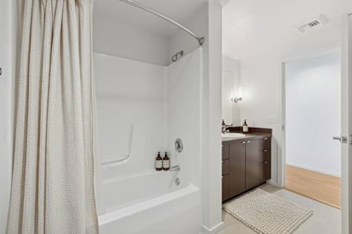 A bathroom with a white tub and a shower curtain.