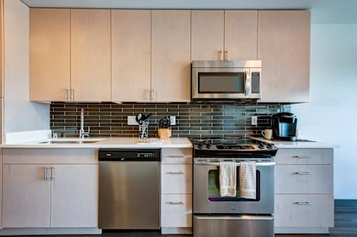 A modern kitchen with a stainless steel dishwasher and oven.