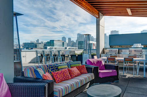 A colorful outdoor seating area with a view of the city skyline.