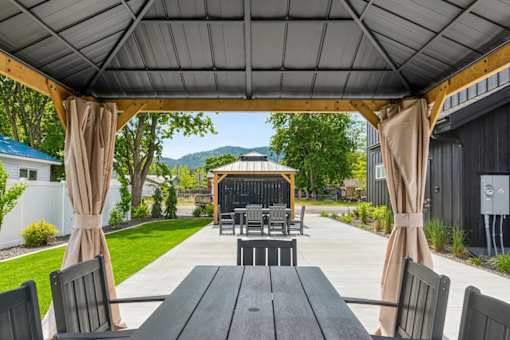 A patio with a table and chairs under a canopy.