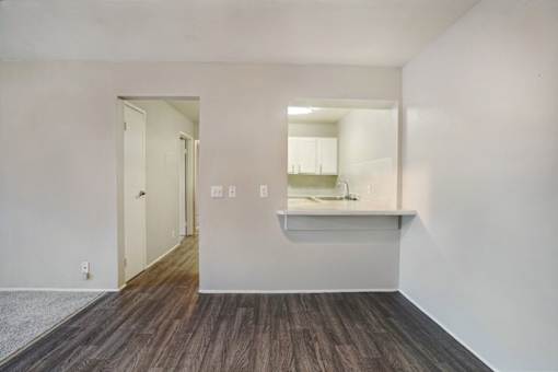A room with a white wall and a wooden floor.
