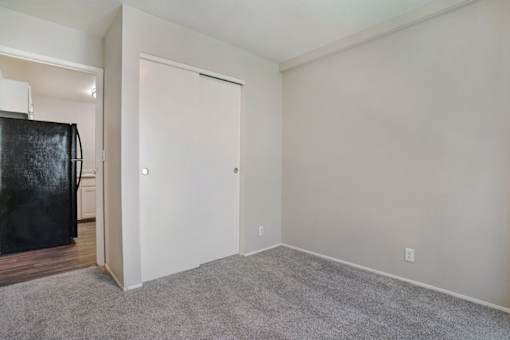 A room with a black fridge and a white door.