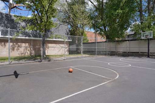 A basketball is in the air, about to be dunked into the hoop.