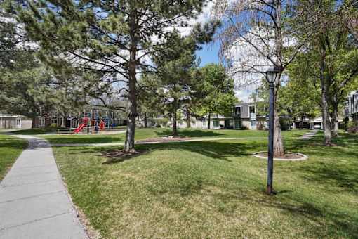 A park with a playground and a lamp post.