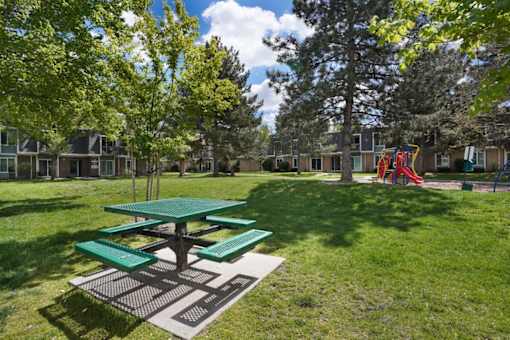 A picnic table is in the middle of a playground.