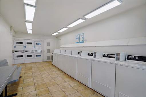A laundry room with washing machines and dryers.