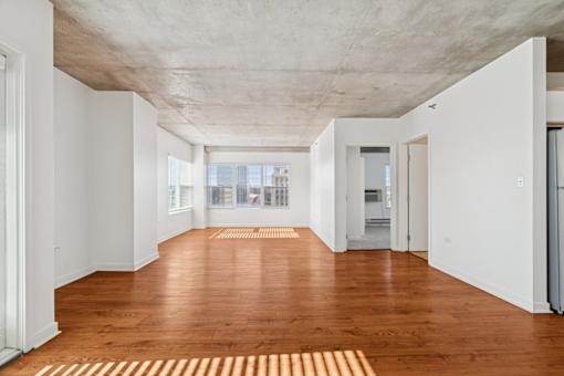 A long hallway with a wooden floor and white walls.