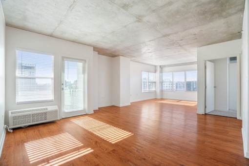 A room with wooden floors and a concrete ceiling.