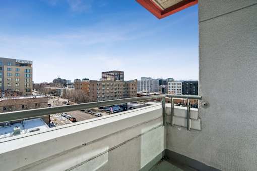 A balcony with a view of a cityscape and buildings.