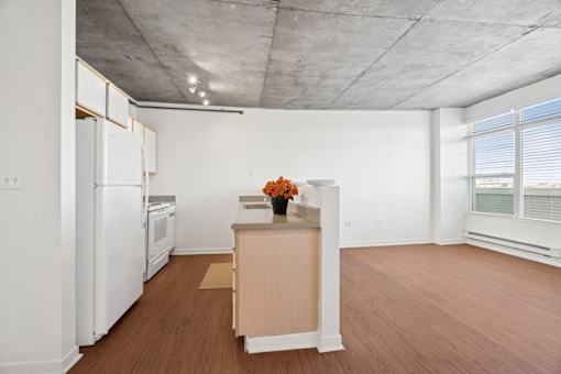 A kitchen with white appliances and wooden floors.