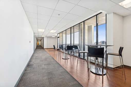 A long hallway with chairs and a carpeted floor.