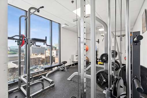 A gym with a view of the city outside the window.