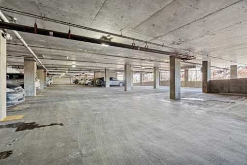 A large, empty parking garage with concrete pillars and floors.