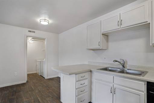 A kitchen with white cabinets and a sink.