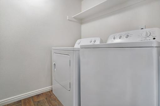 A white washing machine and dryer in a small room.