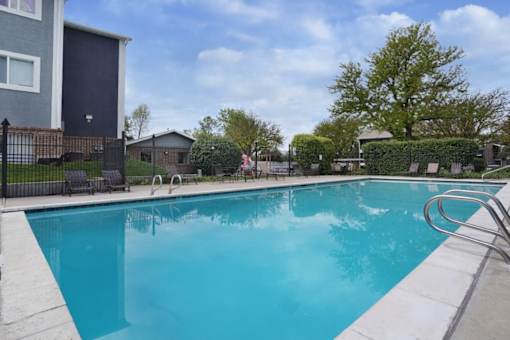A blue swimming pool surrounded by a black fence.