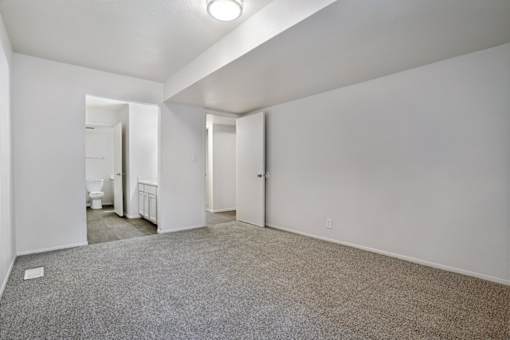 A spacious room with a carpeted floor and white walls.