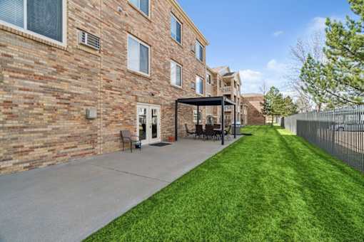 A long grassy area in front of a brick building.