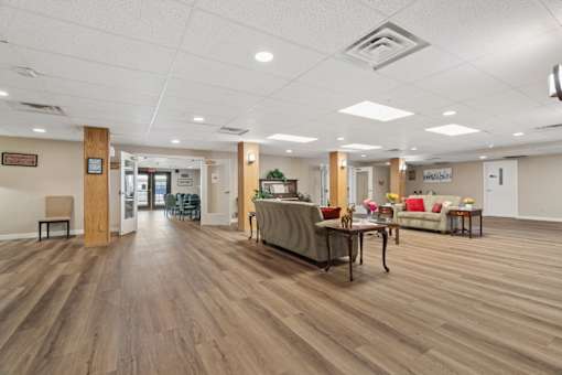 A spacious room with wooden floors and furniture.